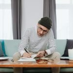 person sitting on lounge working through finances