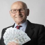 man in black suit holding dollar bills